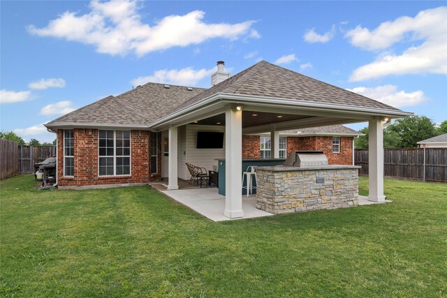 rear view of property featuring brick siding, area for grilling, a fenced backyard, a lawn, and a patio