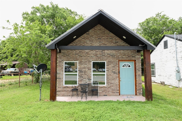 back of property featuring fence, a patio, a yard, and brick siding
