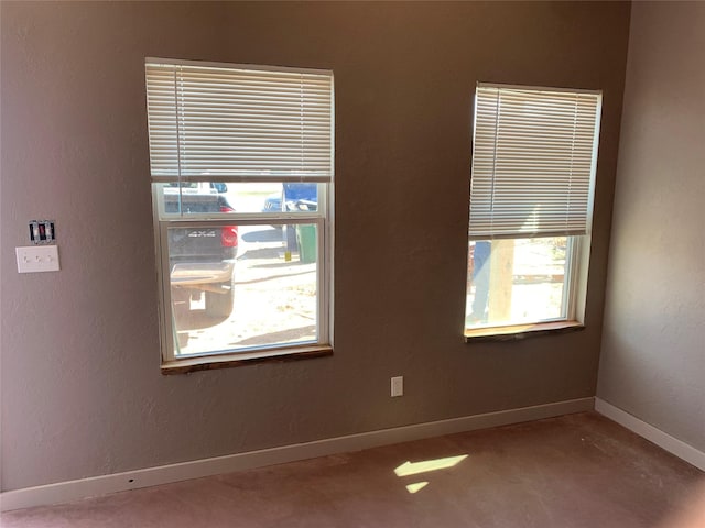 empty room featuring baseboards and concrete floors