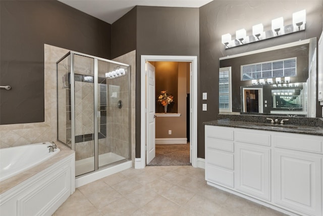 bathroom featuring tile patterned flooring, a garden tub, vanity, baseboards, and a shower stall