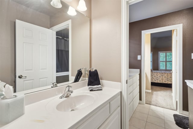 ensuite bathroom featuring vanity, baseboards, tile patterned floors, and connected bathroom