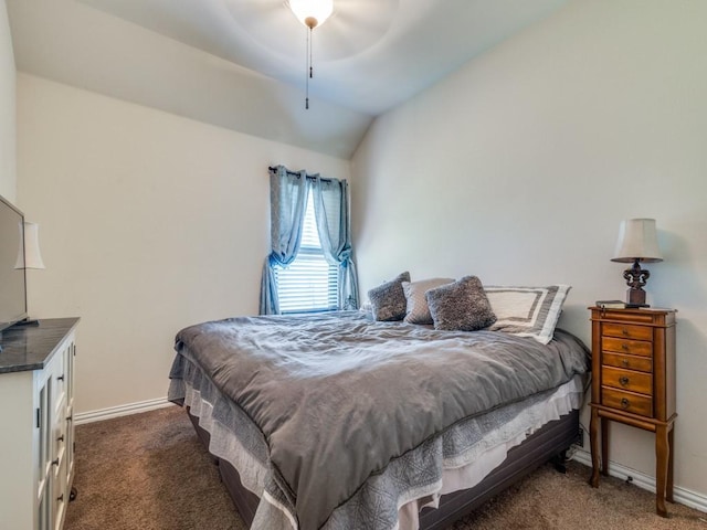 bedroom with baseboards, vaulted ceiling, and dark colored carpet