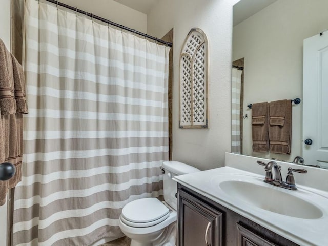 bathroom featuring vanity, curtained shower, and toilet