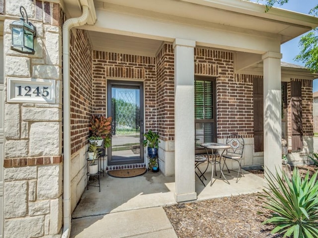 doorway to property featuring brick siding and stone siding