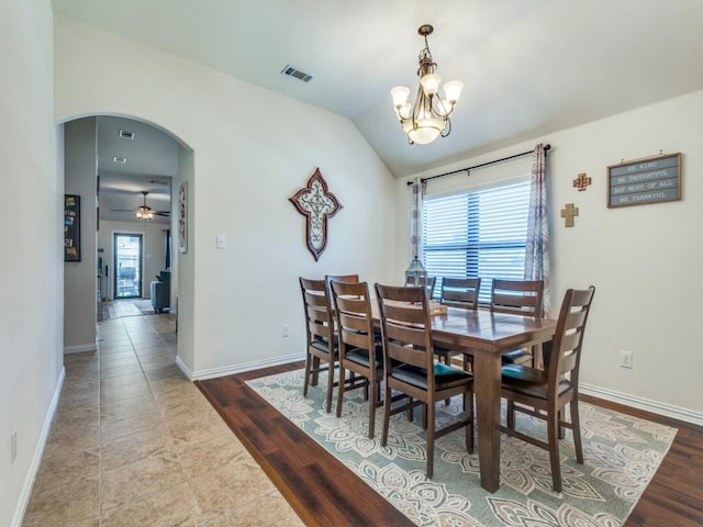 dining area with visible vents, arched walkways, baseboards, a notable chandelier, and lofted ceiling