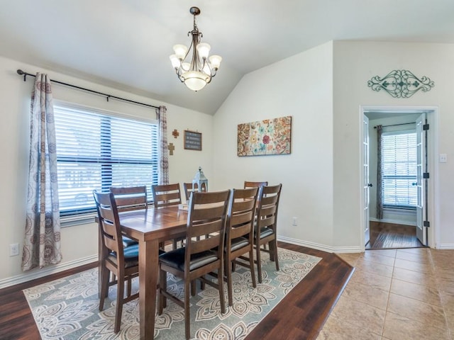 tiled dining area with a healthy amount of sunlight, baseboards, and an inviting chandelier