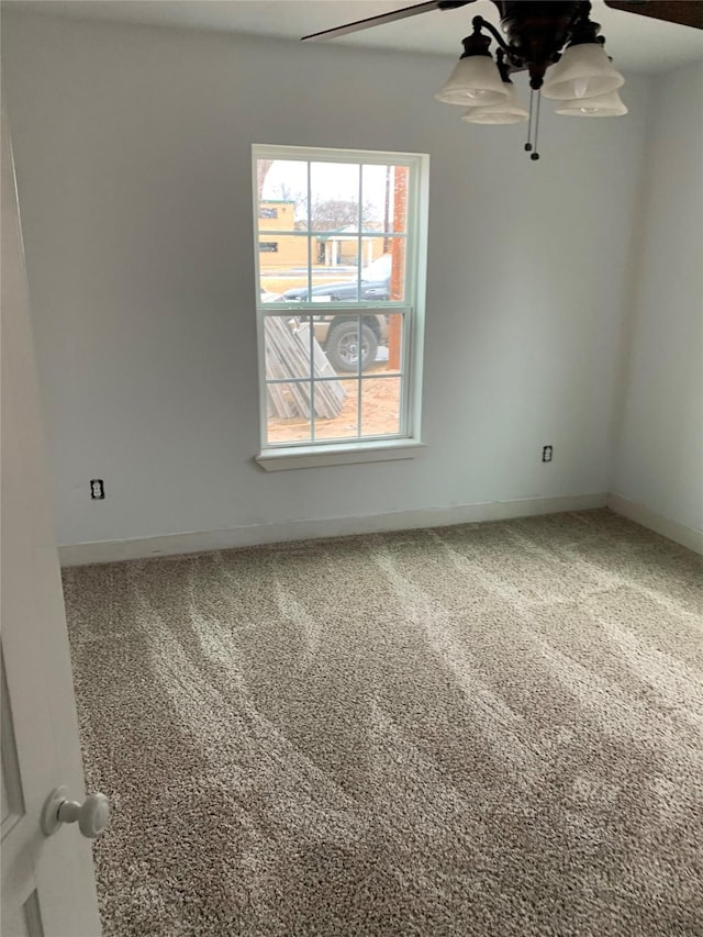 carpeted empty room with baseboards and ceiling fan