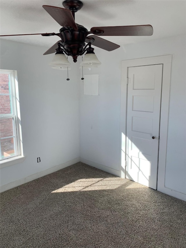 spare room with baseboards, a ceiling fan, and carpet