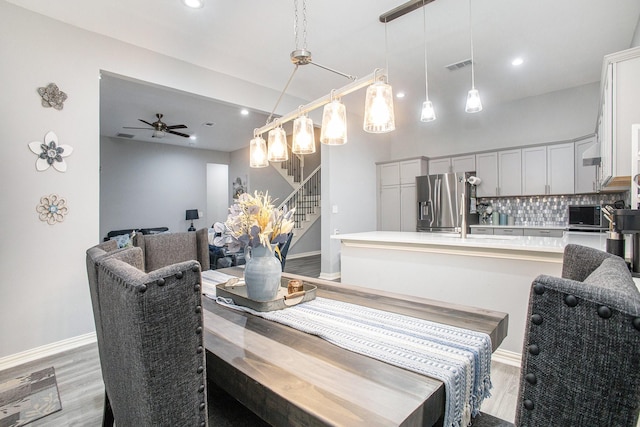 dining area with stairs, light wood-style floors, recessed lighting, ceiling fan, and baseboards