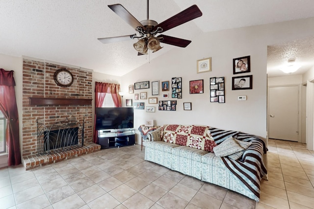 living area with tile patterned flooring, a fireplace, a textured ceiling, a ceiling fan, and vaulted ceiling