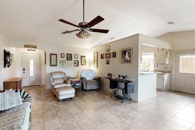 living room featuring light tile patterned floors, a ceiling fan, vaulted ceiling, and visible vents