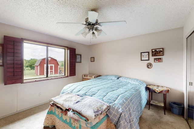 bedroom with carpet flooring, a textured ceiling, ceiling fan, and a closet