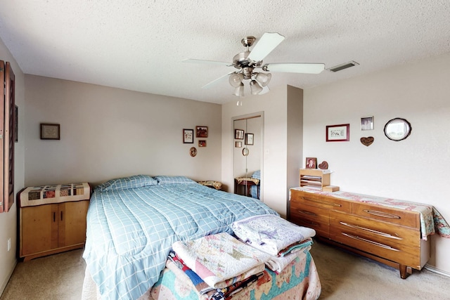 bedroom with visible vents, a textured ceiling, and light colored carpet