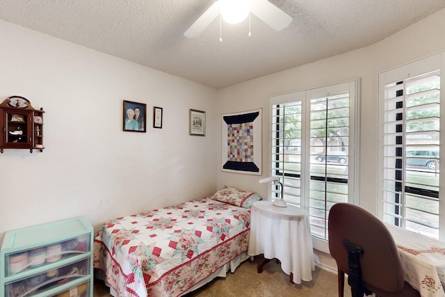 carpeted bedroom with a textured ceiling and ceiling fan