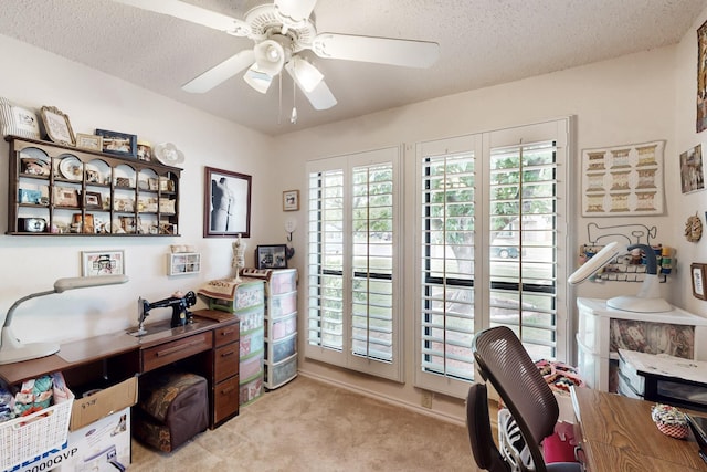office with a ceiling fan, a textured ceiling, and light colored carpet