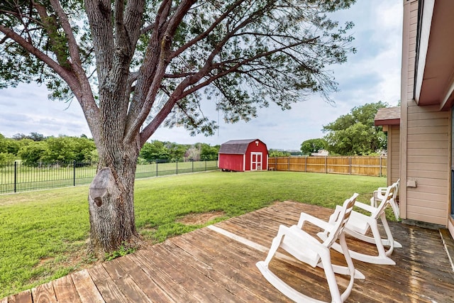 wooden deck with a lawn, a fenced backyard, a shed, and an outdoor structure