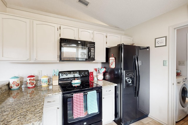 kitchen featuring visible vents, washer / dryer, white cabinets, black appliances, and vaulted ceiling