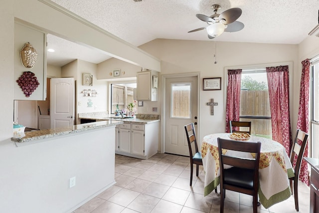 kitchen featuring a ceiling fan, a textured ceiling, and vaulted ceiling