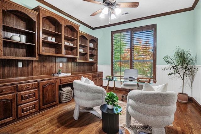 3401 Anthony Cir, Rowlett, TX 75088 - office featuring wainscoting, ceiling fan, dark wood-type flooring, crown molding, and built in desk