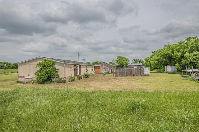 view of yard featuring fence and an outdoor structure