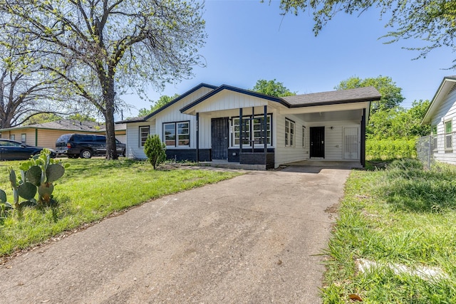 view of front of home featuring a porch, board and batten siding, an attached carport, and driveway