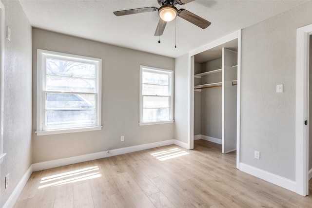 unfurnished bedroom with baseboards, ceiling fan, a closet, and light wood finished floors