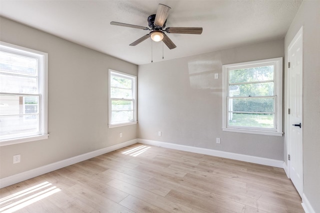 spare room with light wood-style floors, baseboards, and a ceiling fan