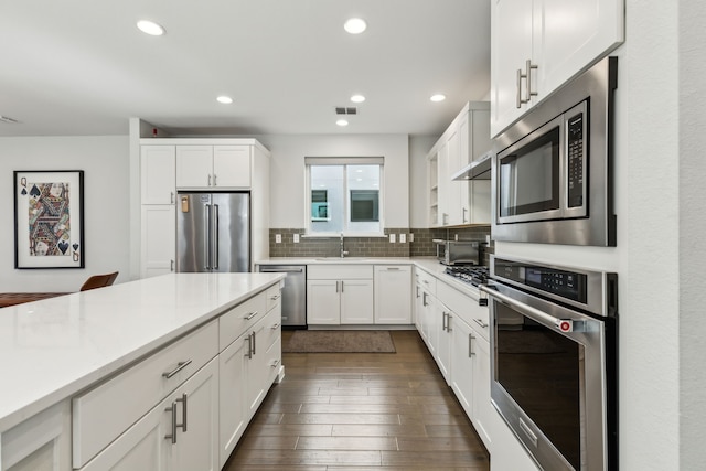 5424 Anita St, Dallas, TX 75206 - kitchen with stainless steel appliances, a sink, recessed lighting, decorative backsplash, and dark wood-type flooring