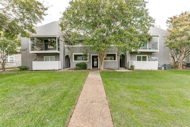 view of front of home with central air condition unit, stucco siding, and a balcony