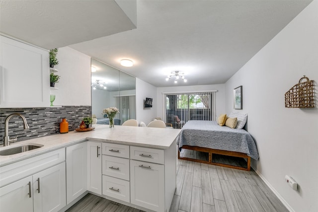 bedroom with baseboards, a sink, and light wood-type flooring