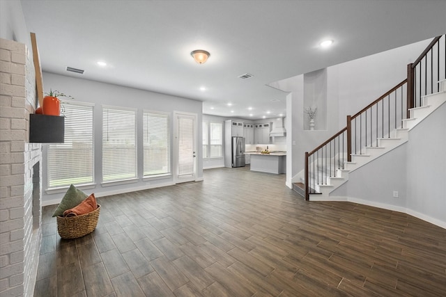 2812 Bluff Creek Dr, Mansfield, TX 76063 - unfurnished living room featuring visible vents, stairs, a brick fireplace, baseboards, and dark wood-type flooring