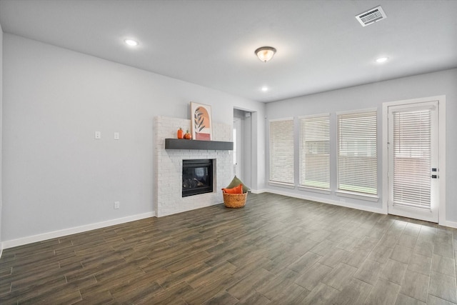 2812 Bluff Creek Dr, Mansfield, TX 76063 - unfurnished living room featuring dark wood-style flooring, visible vents, a brick fireplace, baseboards, and recessed lighting
