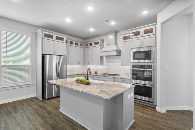 2812 Bluff Creek Dr, Mansfield, TX 76063 - kitchen featuring appliances with stainless steel finishes, baseboards, decorative backsplash, visible vents, and custom exhaust hood