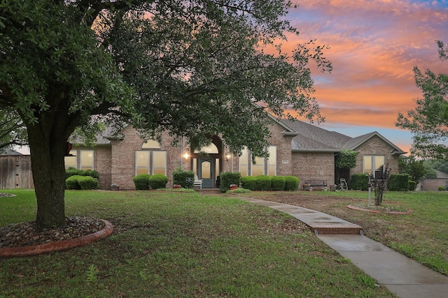 view of front of house with brick siding and a front yard