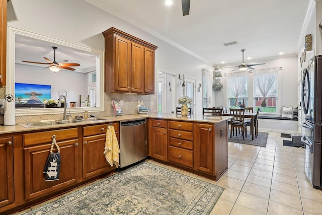 kitchen featuring a ceiling fan, a sink, stainless steel appliances, and a peninsula