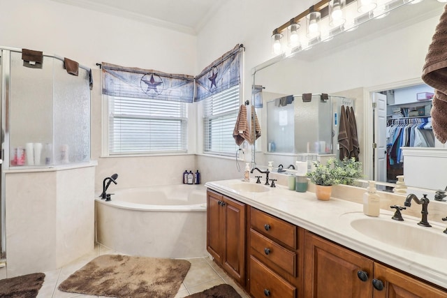 bathroom featuring double vanity, a sink, a bath, and a stall shower