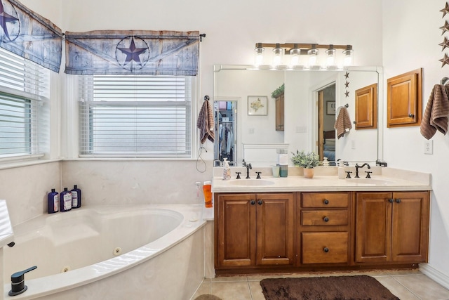 bathroom with a sink, tile patterned flooring, a tub with jets, and double vanity