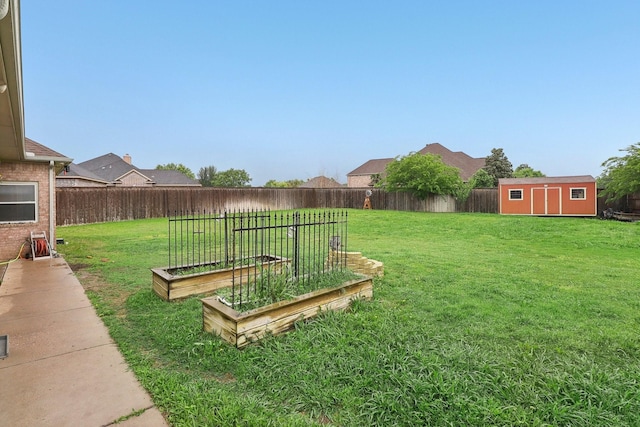view of yard with an outdoor structure, a garden, a shed, and a fenced backyard