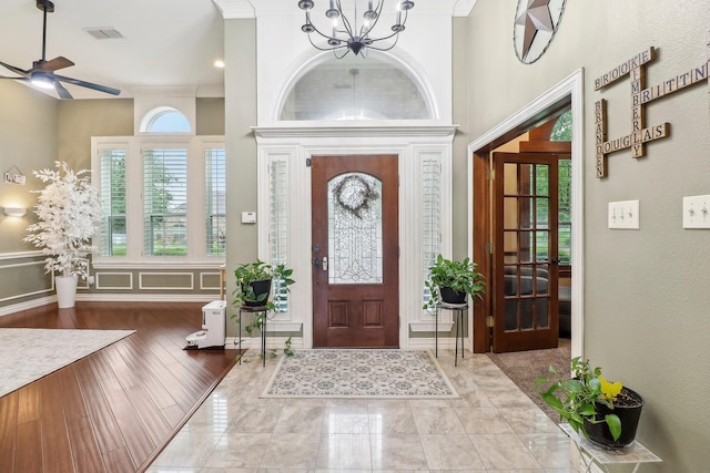 foyer with visible vents and ceiling fan with notable chandelier
