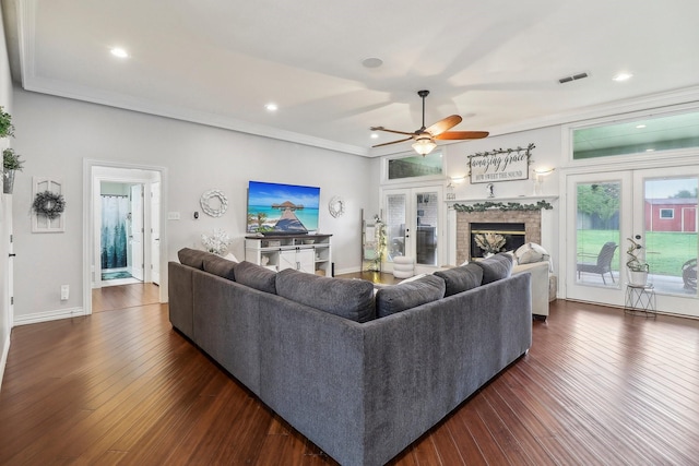 living area featuring visible vents, dark wood-type flooring, ceiling fan, and crown molding