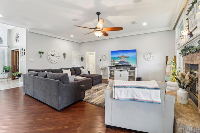 living area with visible vents, ornamental molding, a glass covered fireplace, recessed lighting, and a ceiling fan