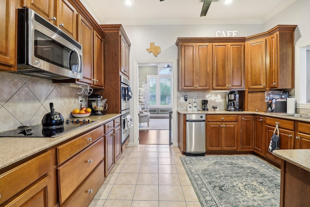 kitchen featuring brown cabinetry, ornamental molding, light tile patterned floors, appliances with stainless steel finishes, and backsplash