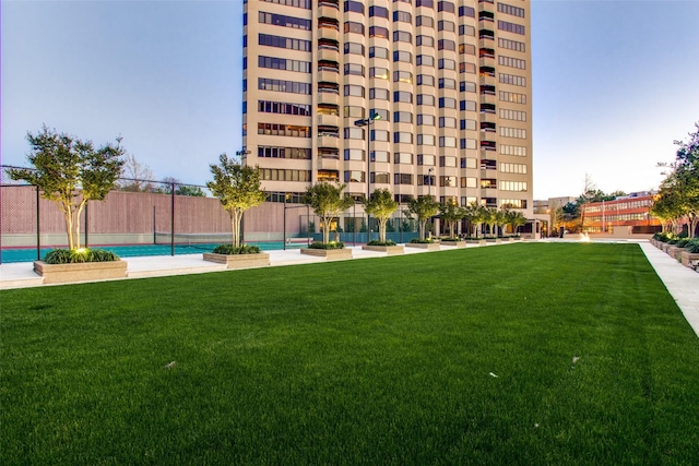 pool featuring a lawn and fence