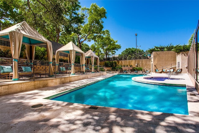 view of pool featuring a patio area, an in ground hot tub, and fence