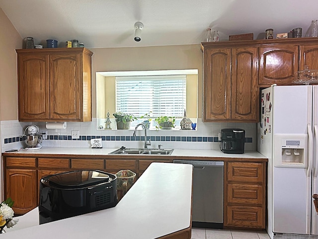 1561 Waterford Dr, Lewisville, TX 75077 - kitchen with white fridge with ice dispenser, a sink, stainless steel dishwasher, light countertops, and decorative backsplash