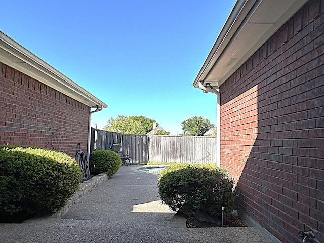 1561 Waterford Dr, Lewisville, TX 75077 - view of property exterior featuring brick siding and a fenced backyard