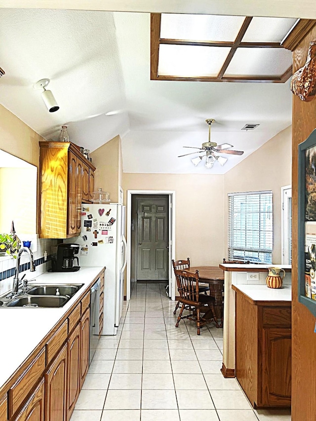 1561 Waterford Dr, Lewisville, TX 75077 - kitchen with a sink, lofted ceiling, brown cabinetry, ceiling fan, and light countertops