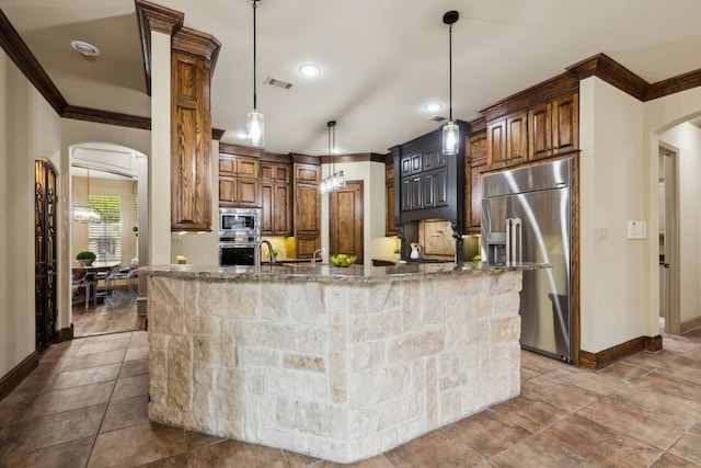 kitchen with crown molding, arched walkways, and built in appliances
