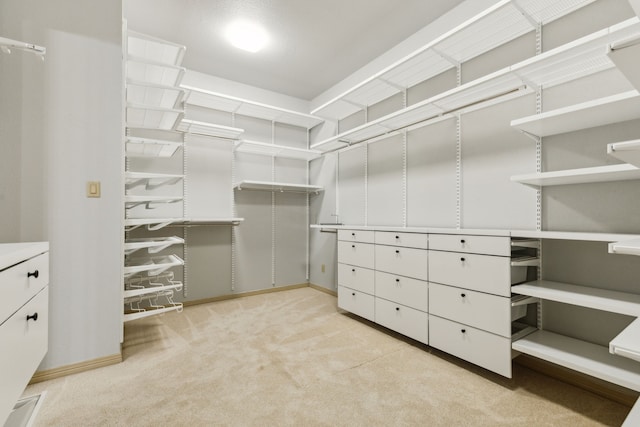 walk in closet with light carpet