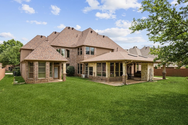 back of house with a patio area, fence, a yard, and roof with shingles